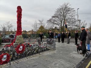 people standing round war memorial