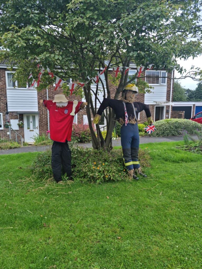 fireman scarecrow and scarecrow wearing red England shirt