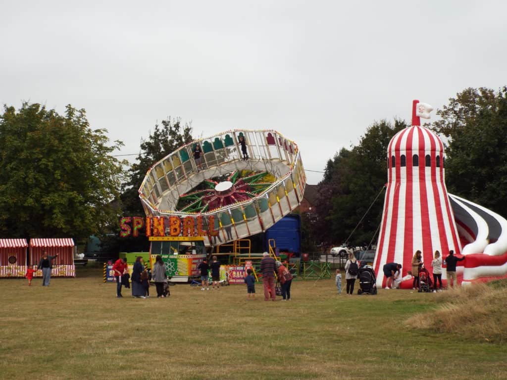 red and white helter skelter and spinning wheel on grass field