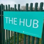 green hub sign on fence