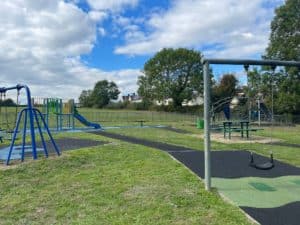 swings on green grass at station road