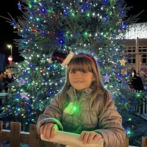girl pressing the button for christmas lights