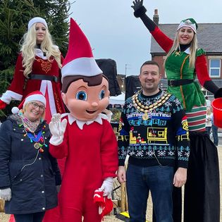 giant elf and stilt walkers with mayor