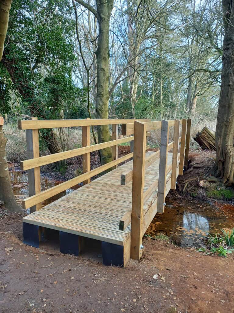 wooden bridge at manor park in trees