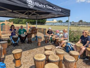 Photo of adults and children at the African drumming workshop
