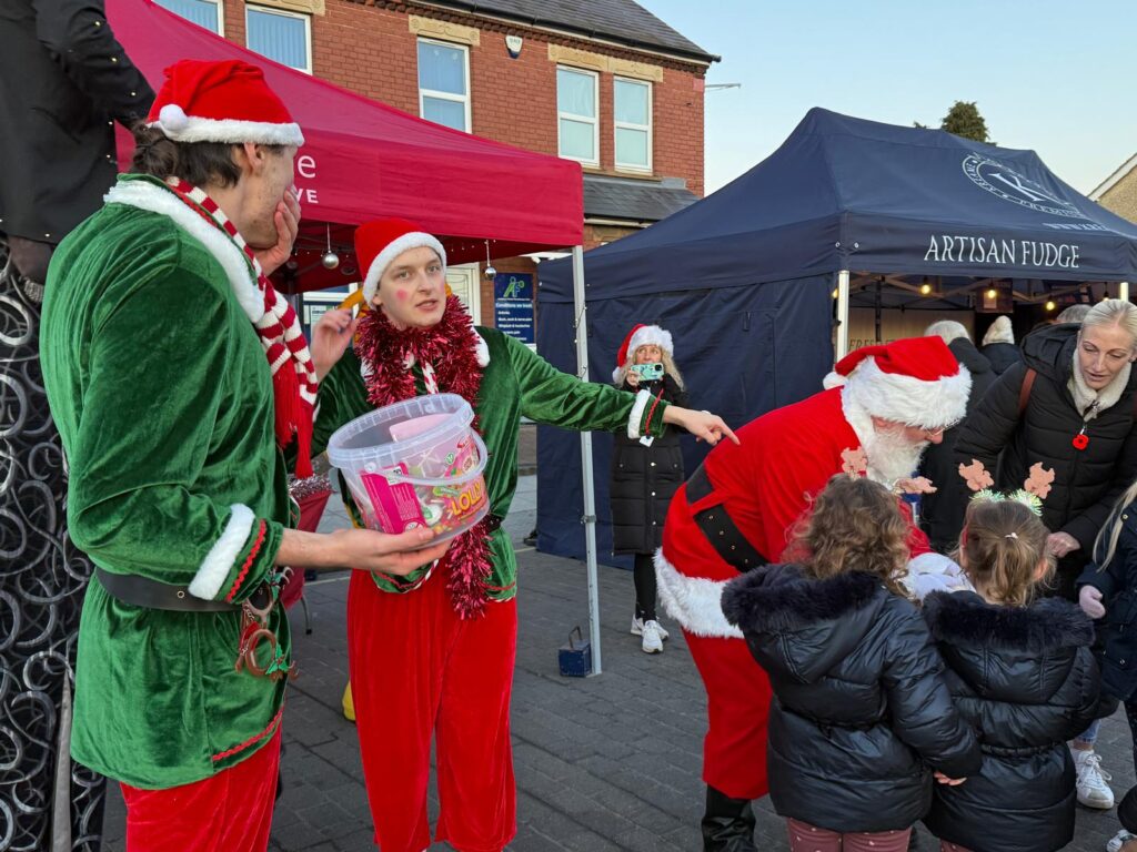 Photo of Santa and Elves at Christmas lights switch on.