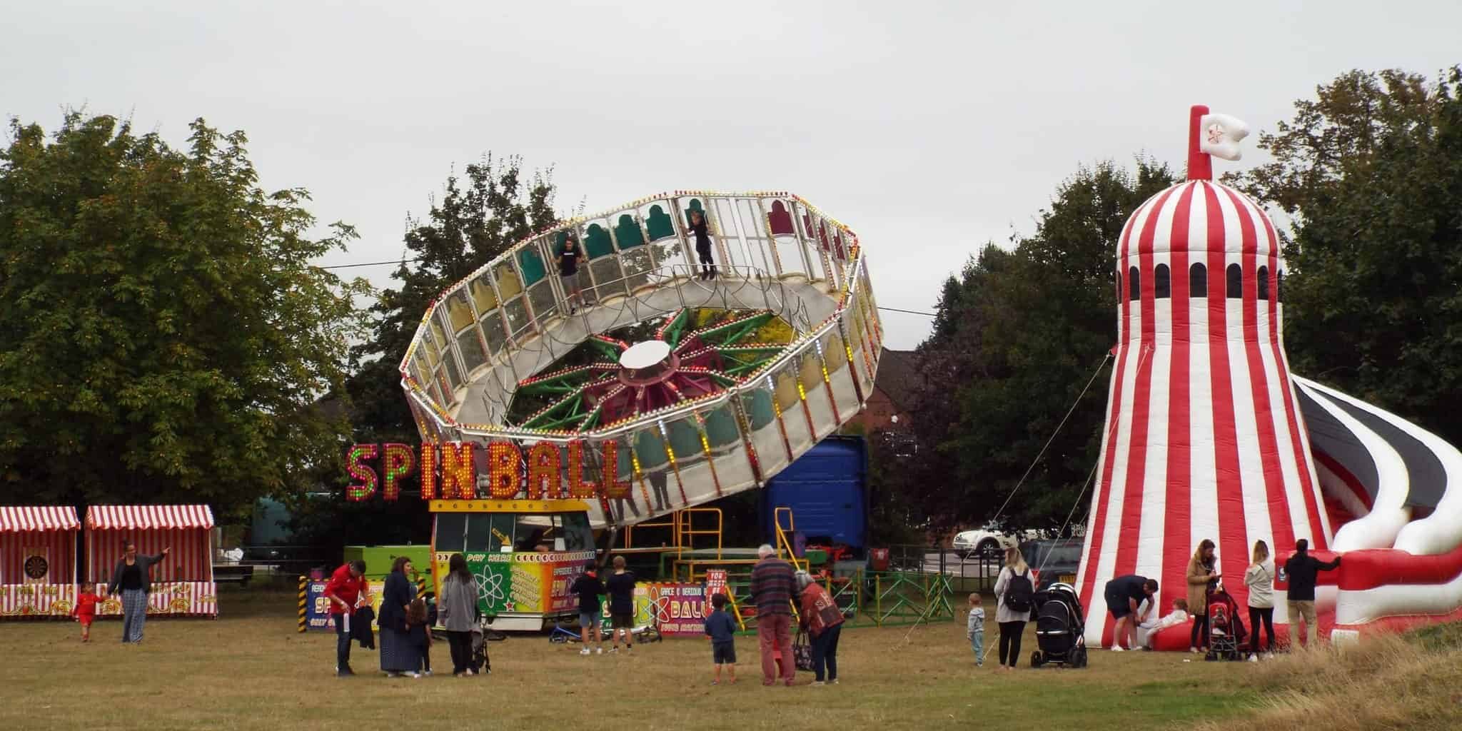 red and white helter skelter and spinning wheel on grass field